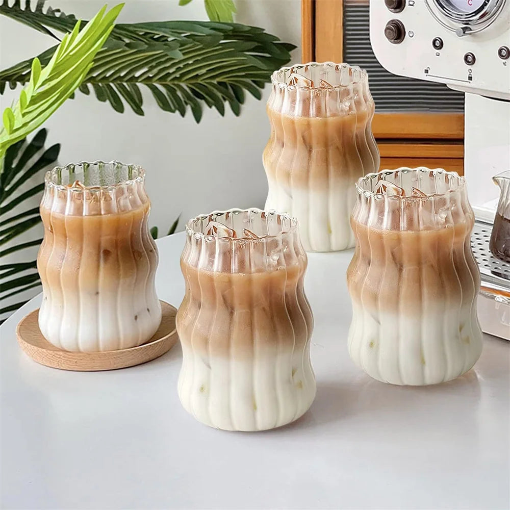 Drei Riffelgläser nebeneinander mit geschichtetem Milchkaffee